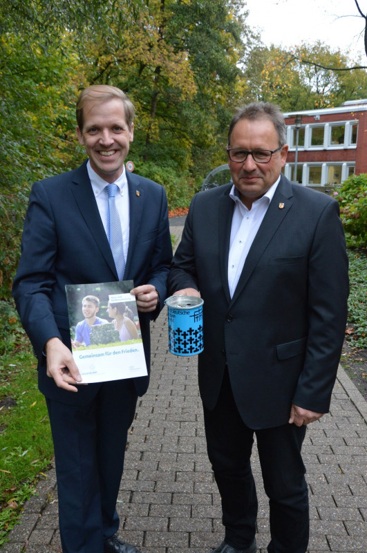 Landrat Dr. Christian Schulze Pellengahr und Kreisgeschäftsführer Thomas Bleiker (rechts) mit Plakat und Spendendose des Volksbundes 